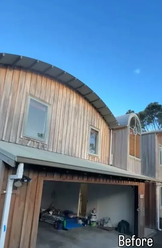 Curved-roof Auckland home before painting, with weathered natural timber cladding
