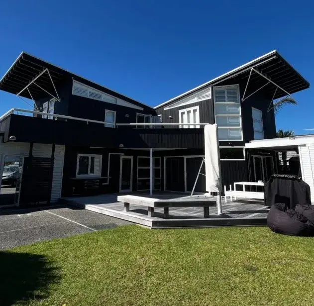 Modern two-storey black painted home with deck in Auckland