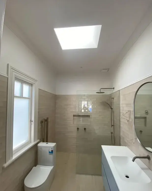 Bathroom interior with freshly painted ceiling and walls, tiled feature wall