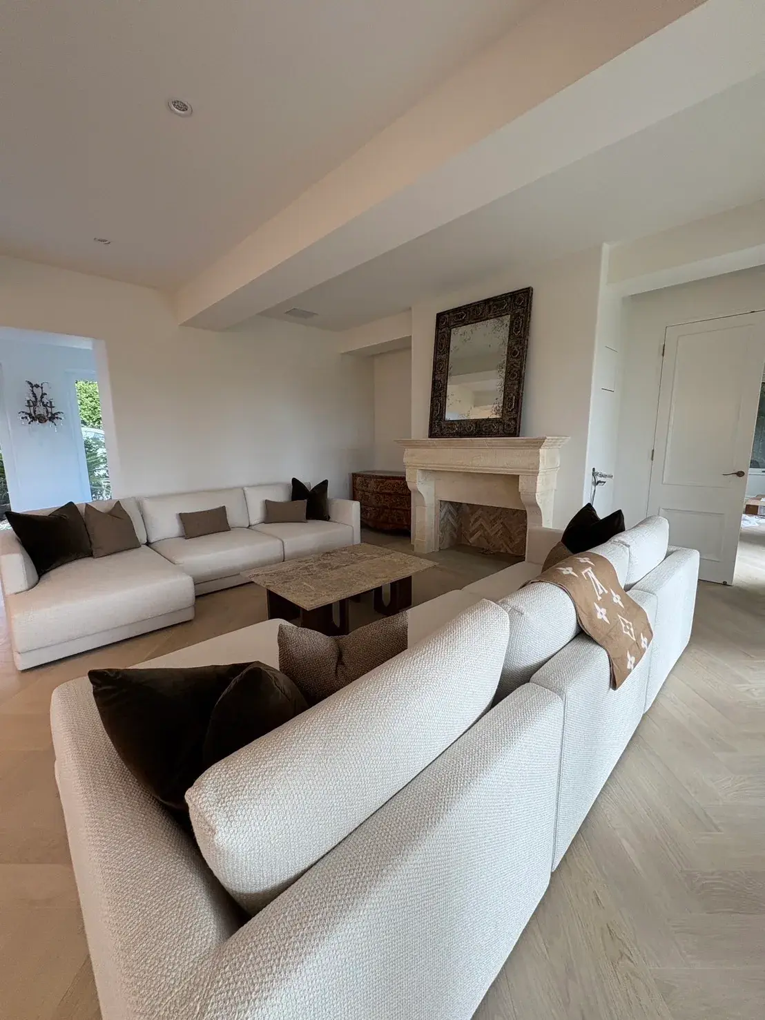 Warm white painted living room with stone fireplace and herringbone oak floor